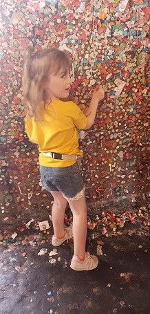 Megan placing gum on Gum Alley wall